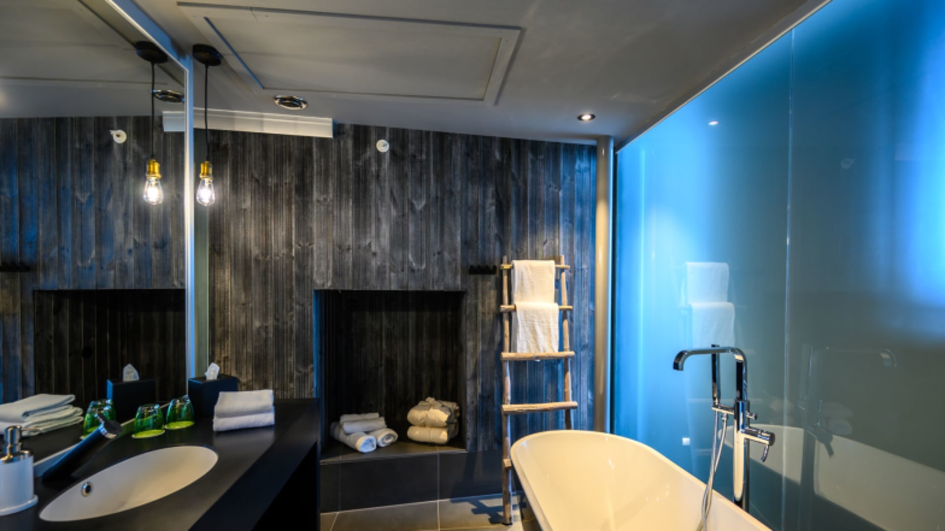 Luxuriöses Badezimmer im Aurora Room des Hamn i Senja mit freistehender Wanne und LED-Beleuchtung.