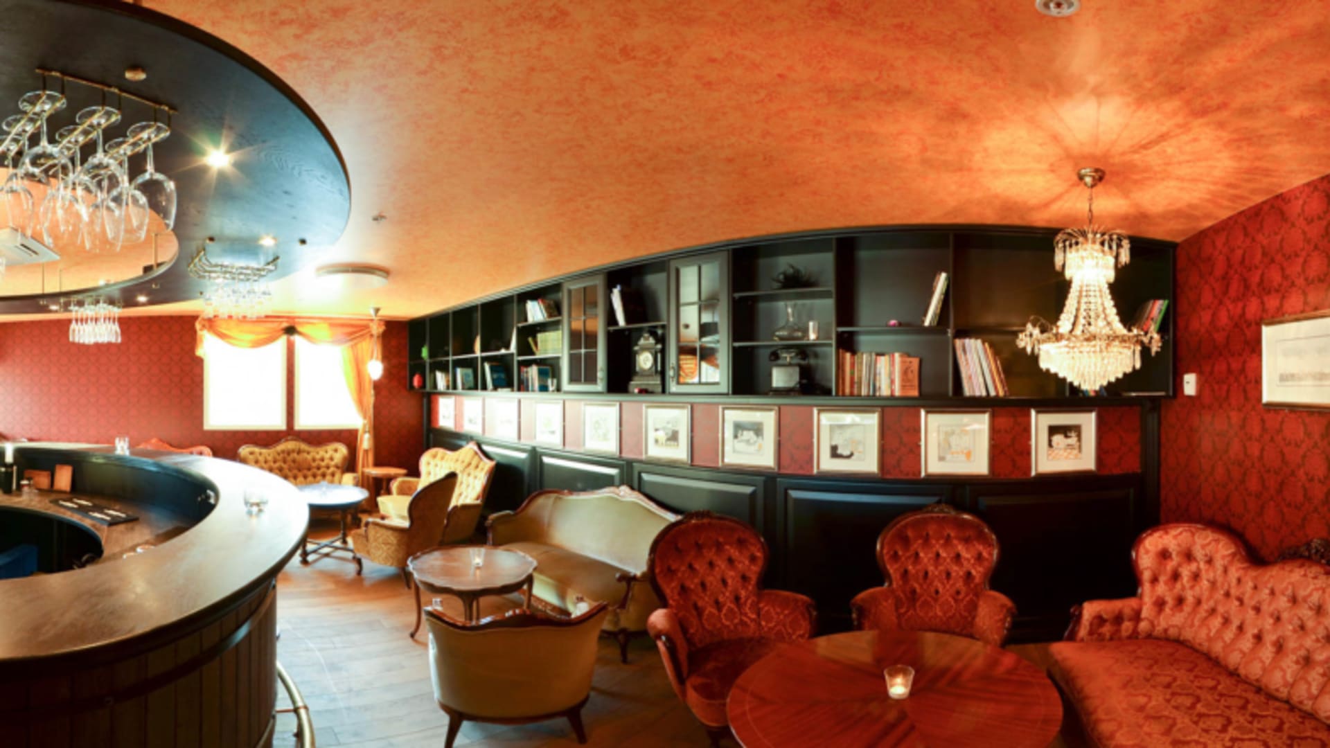 Luxuriöse Bar-Lounge im Hamn i Senja mit roten Samtsesseln und dunkler Holzverkleidung.