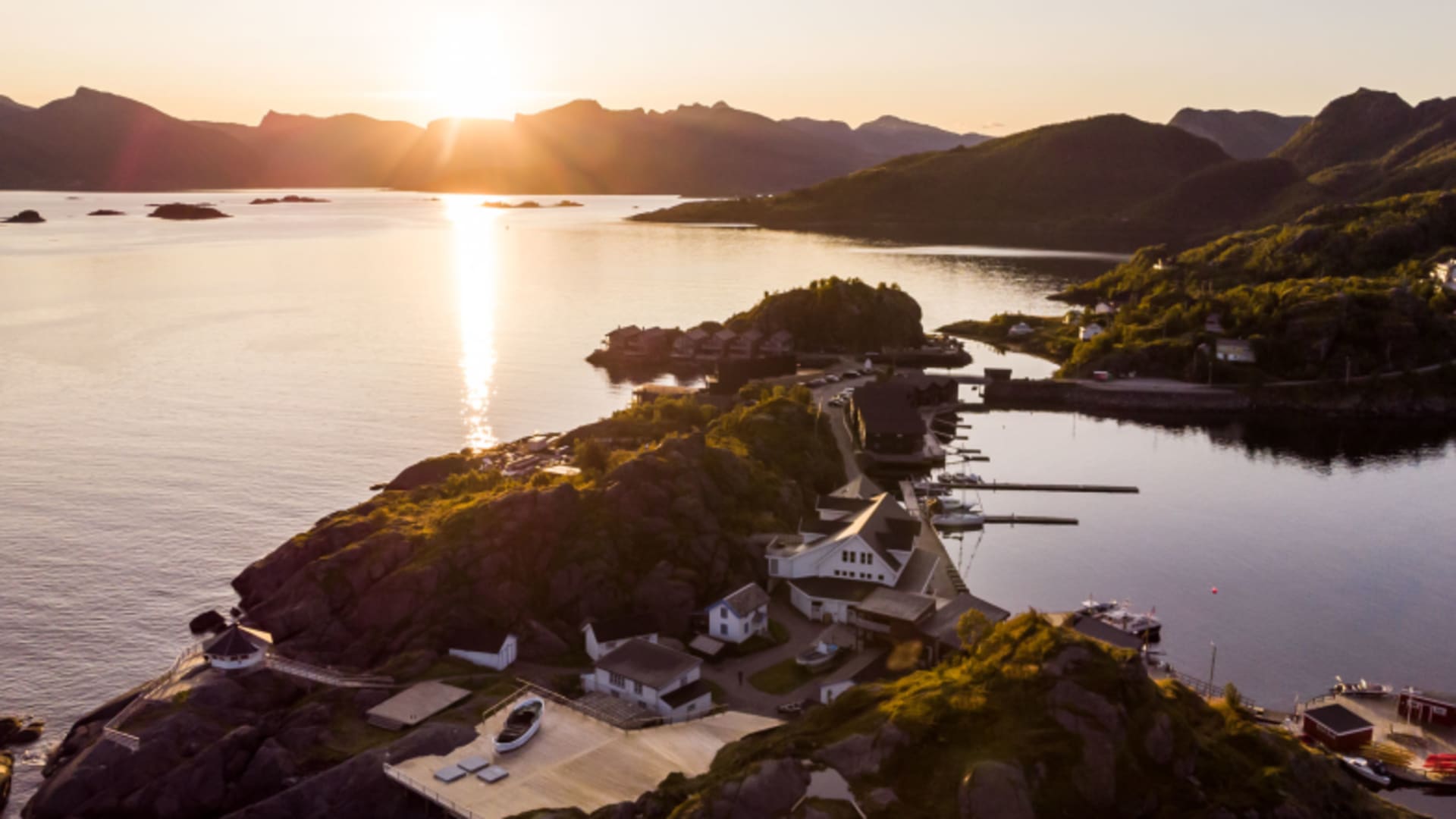 Luftaufnahme des Hamn i Senja Komplexes auf felsiger Halbinsel im Fjord bei Sonnenuntergang.