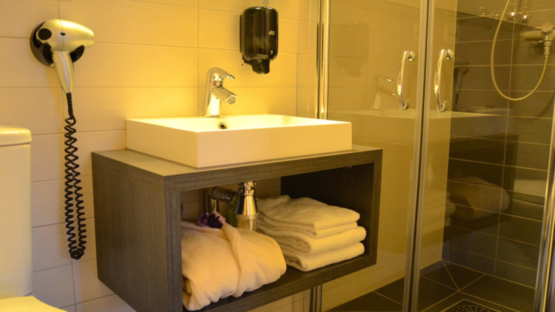 Modernes Badezimmer im Hamn i Senja mit Holzwaschtisch und verglaster Duschkabine.