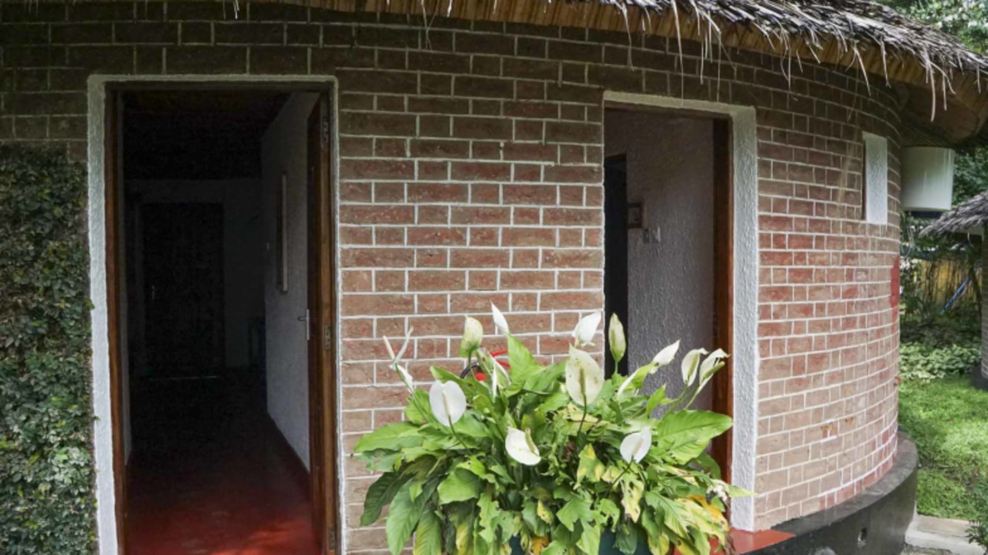 Rundes Gästegebäude mit Backsteinwänden und Strohdach in der Ilboru Safari Lodge.
