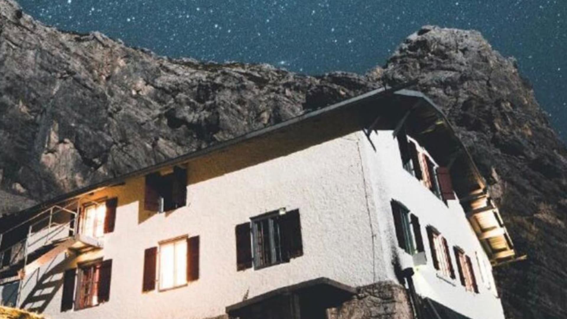 Nachtaufnahme der beleuchteten Knorrhütte vor der steilen Felswand des Zugspitzmassivs.