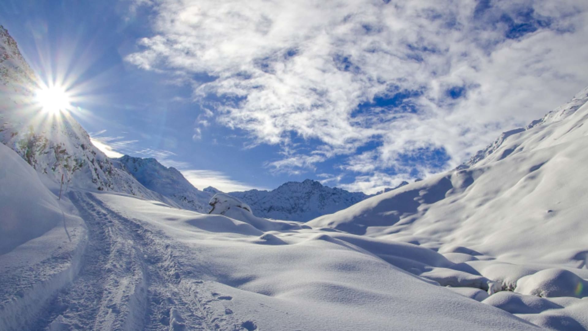Getretene Spur führt durch unberührte Schneehänge zum Zustieg der Potsdamer Hütte bei strahlend blauem Himmel.