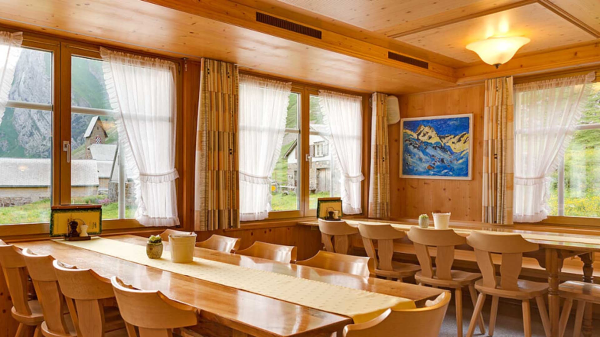 Traditioneller Gastraum im Berggasthaus Meglisalp mit Holzverkleidung und rustikalen Möbeln.