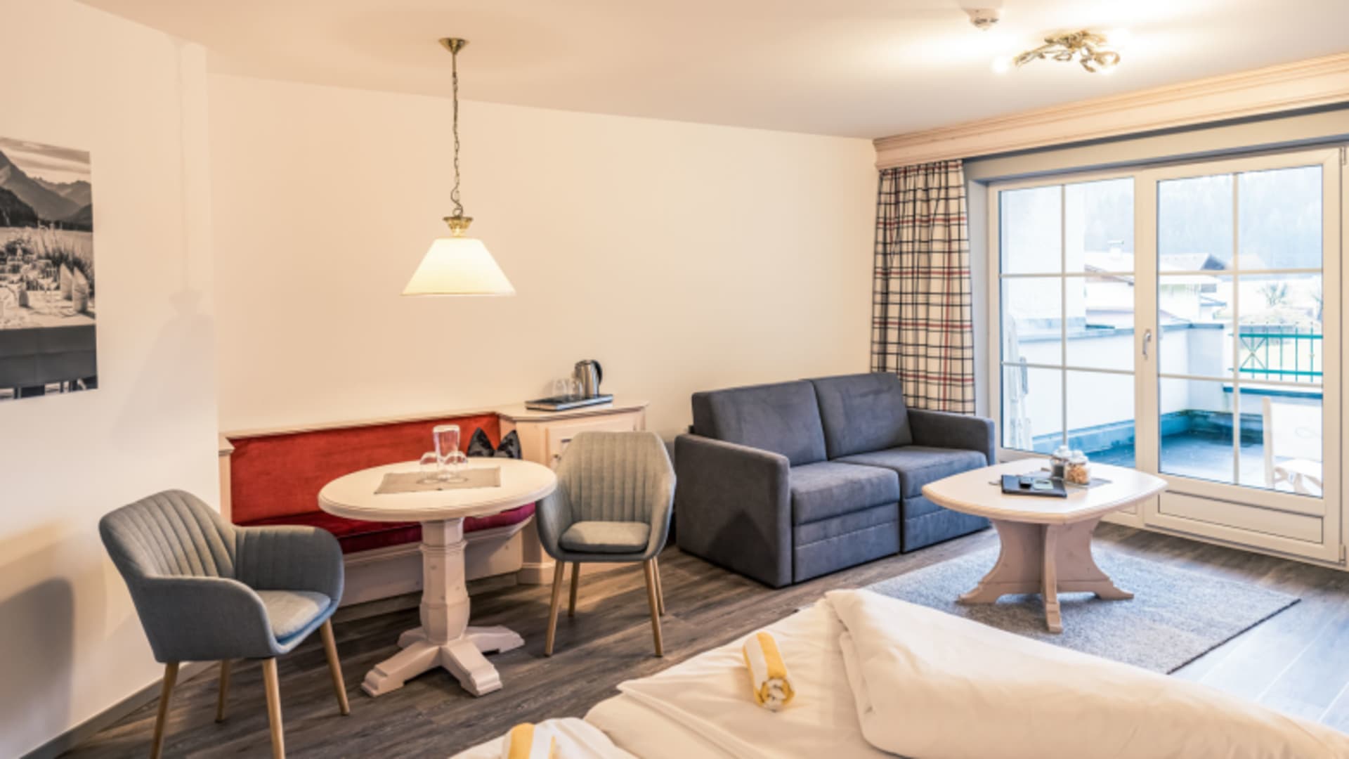 Geräumige Suite im Hotel Föhrenhof mit separatem Wohnbereich und modernem Mobiliar.