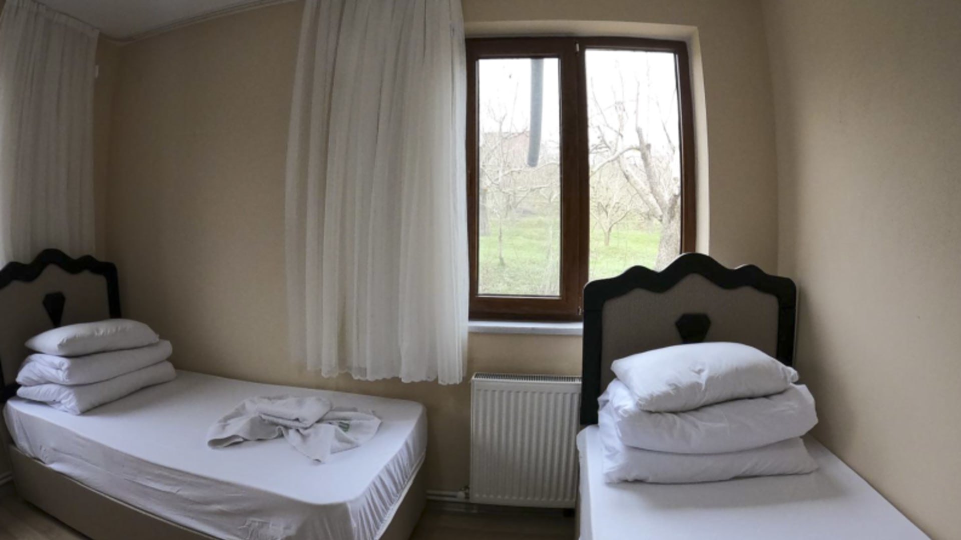 Doppelzimmer mit zwei Einzelbetten im Taurus Guesthouse mit Blick auf grüne Wiesen im Taurusgebirge.