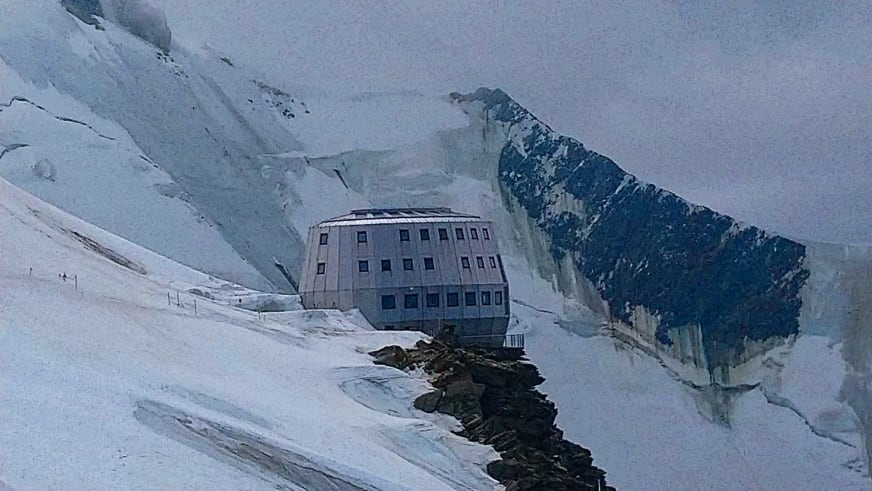 Das Refuge du Goûter steht als moderner Bau auf verschneitem Gletscherplateau im Mont-Blanc-Massiv.