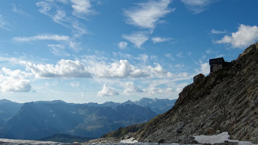 Das Refuge Albert 1er steht auf einem exponierten Felsvorsprung mit Blick über das Tal im Hochgebirge.