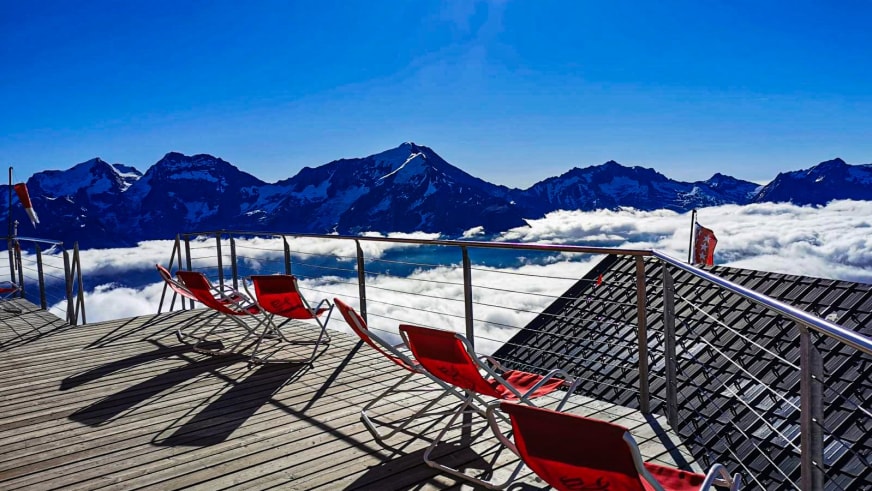 Blick von der Terrasse der Mischabelhütte über eine geschlossene Wolkendecke zu schneebedeckten Berggipfeln.