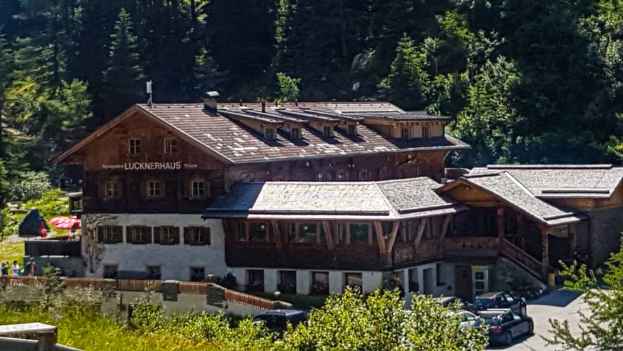 Das Lucknerhaus mit charakteristischer Holzfassade und überdachter Terrasse inmitten von Nadelwald.