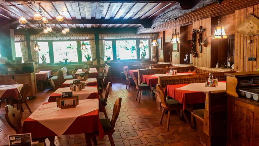 Traditionelle Gaststube im Lucknerhaus mit Holztischen, roten Tischdecken und rustikaler Ausstattung.