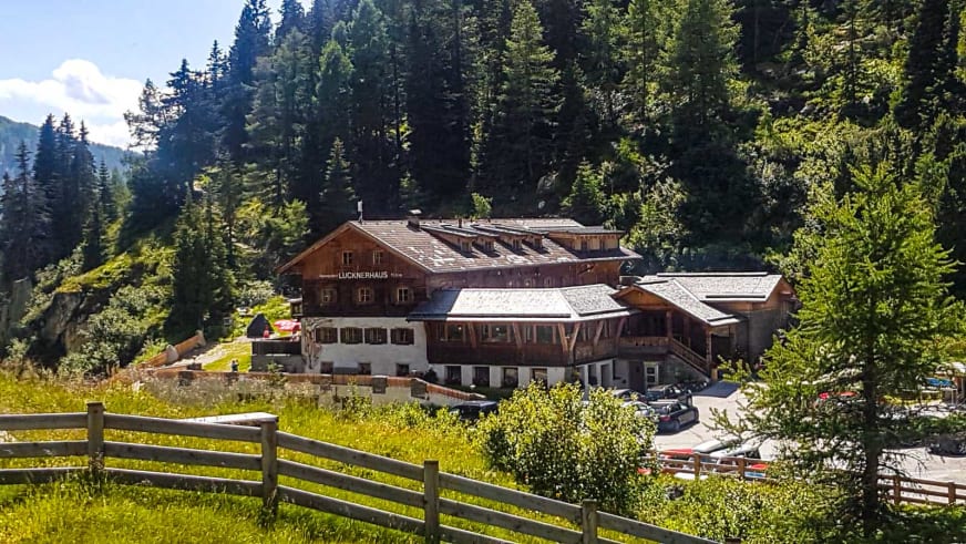 Außenansicht des Lucknerhaus als traditioneller Alpengasthof eingebettet in dichte Nadelwälder.