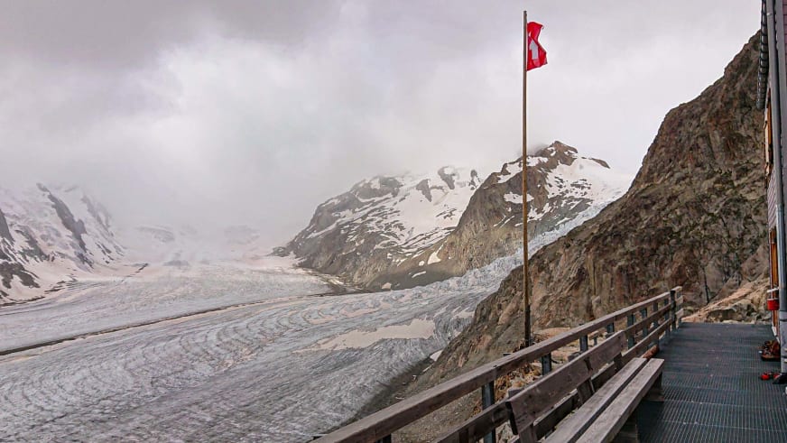 Aussichtsplattform der Konkordiahütte mit Schweizer Fahne und Blick über den Gletscher.