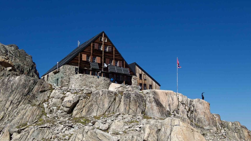 Die Cabane d'Orny erhebt sich auf massivem Felsfundament mit Holzbauweise und modernem Anbau.