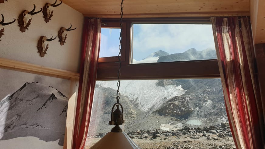 Blick aus der Similaunhütte durch das Fenster auf die umliegende Gletscherlandschaft der Ötztaler Alpen.