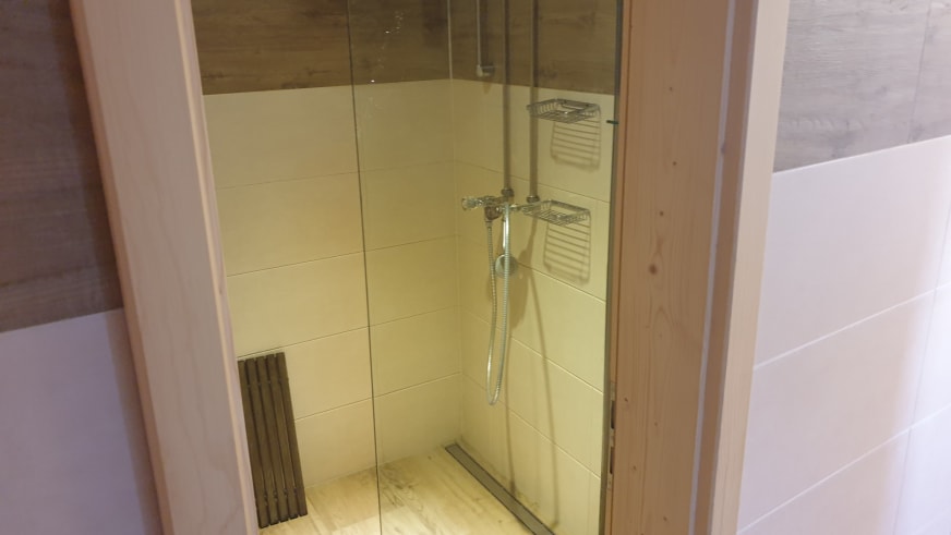 Moderne Duschkabine der Similaunhütte mit Glaswänden, Regendusche und zeitgemäßer Sanitärausstattung.