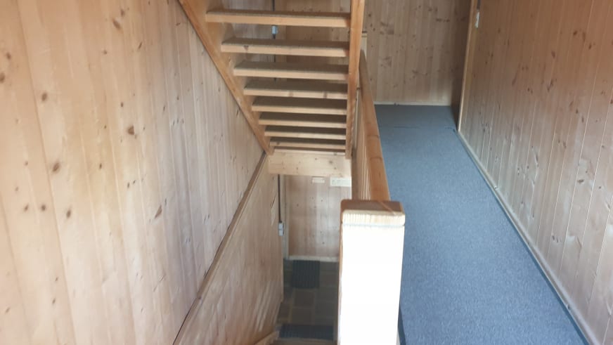 Offenes Holztreppenhaus der Similaunhütte mit geraden Stufen und Handlauf aus naturbelassenem Fichtenholz.