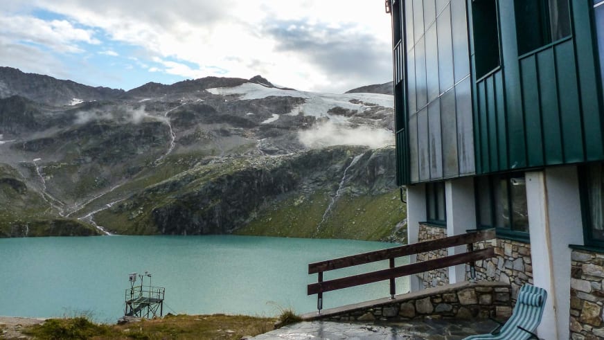 Das Berghotel Rudolfshütte steht mit moderner Glasfassade direkt am türkisfarbenen Weißsee in den Hohen Tauern.