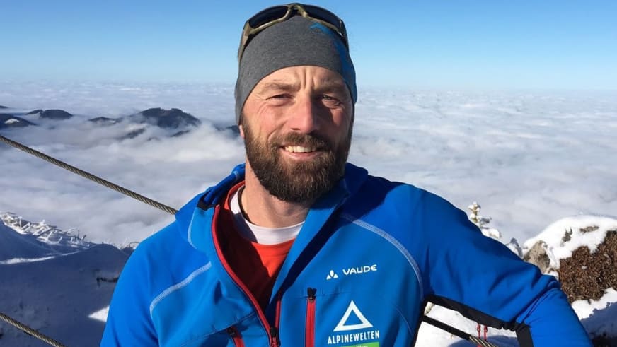 Portrait zeigt Skilehrer Jürgen Brandhuber in blauer Vaude-Jacke mit Vollbart und Skibrille auf der Stirn.