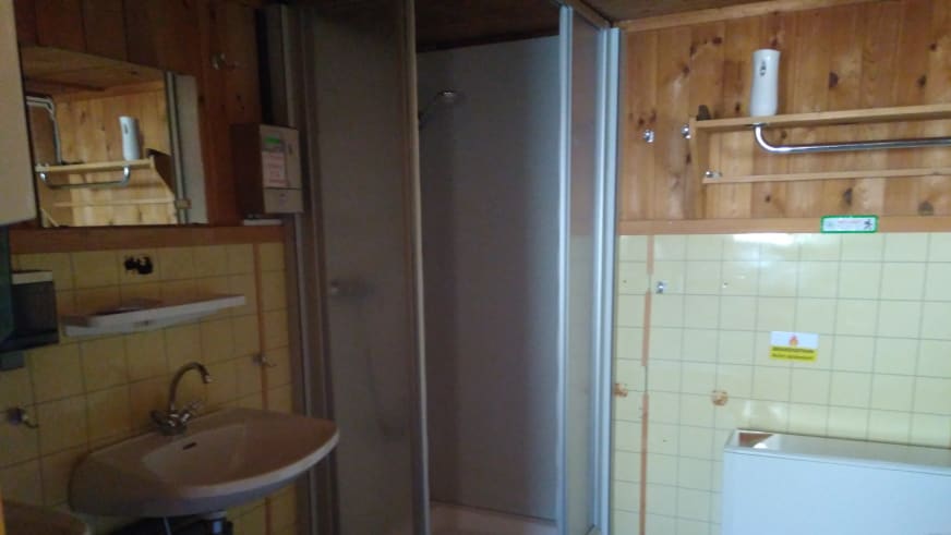 Moderner Waschraum der Siegerlandhütte mit Duschkabine und Waschbecken in Holzvertäfelung.