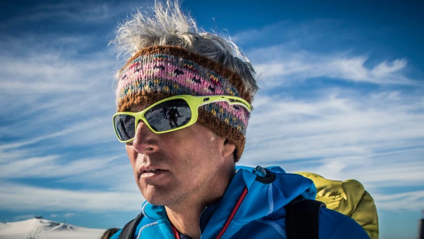 Nahaufnahme-Portrait von Bergführer Martin Bauregger mit buntem Stirnband und neongrüner Gletscherbrille.