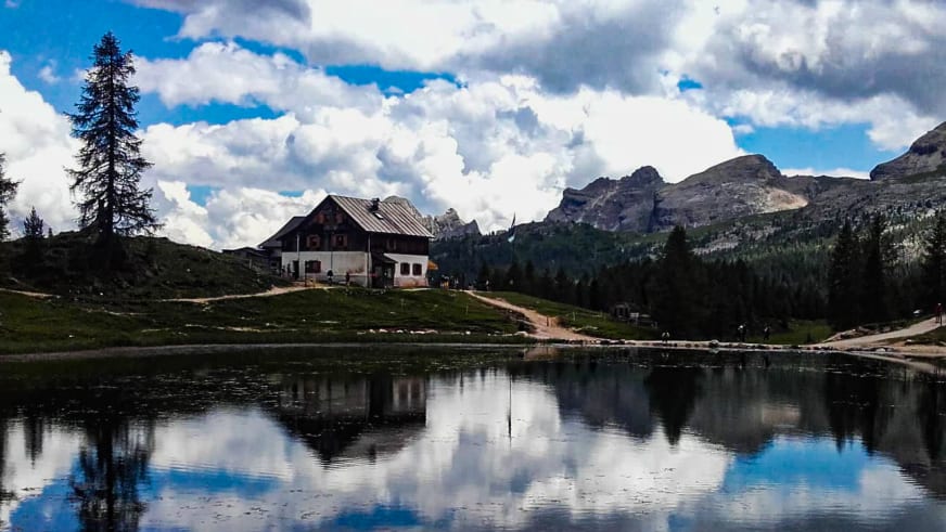 Panorama des Rifugio Croda da Lago am Ufer des Lago Federa mit Spiegelung im ruhigen Bergsee.