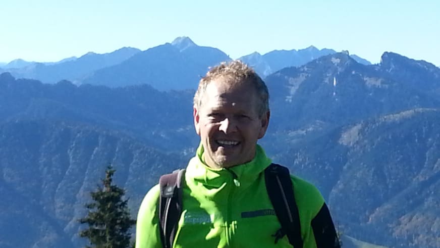 Lächelnder Bergwanderführer Martin Werner in grüner Outdoor-Jacke vor weiter Berglandschaft bei Garmisch.