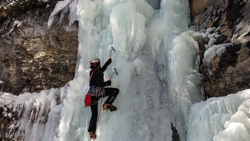 Mit zwei Eisgeräten und Steigeisen klettert Bergführer Peter Klug aktiv an einer gefrorenen Eiswand hinauf.