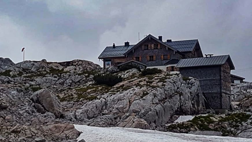 Das Ingolstädter Haus steht auf zerklüftetem Kalksteinfelsen mit Natursteinmauerwerk und Metalldach.