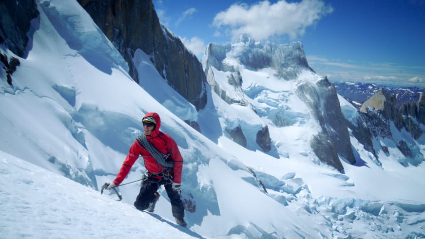 Bergführer Korbinian Schmidtner steigt mit Eispickel über Gletscherspalten am Mont Blanc in steilem Firngelände auf.