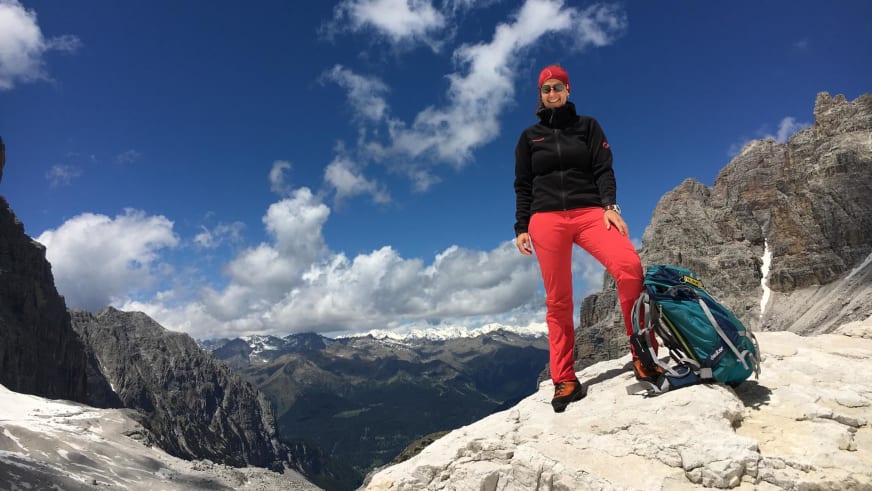 Bergwanderführerin Sabine Kühl steht auf einem Kalksteinfelsen am Watzmann mit Bergpanorama im Hintergrund.
