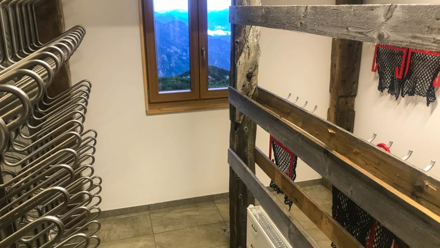 Trockenraum im Stöhrhaus mit Heizkörper und Holzregalen zum Trocknen der Bergausrüstung nach Wanderungen.