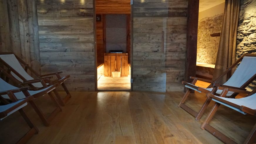 Wellnessbereich der Pensione Ceaglio mit moderner Sauna aus hellem Holz, Liegen und Natursteinwänden.