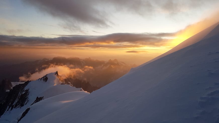 Verschneite Berggipfel in warmer Morgenstimmung zeigen die alpine Welt von Bergführer Martin Riener bei Sonnenaufgang.