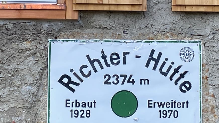 Weißes Hüttenschild der Richterhütte zeigt Höhenangabe 2374 m und Baujahr 1928.
