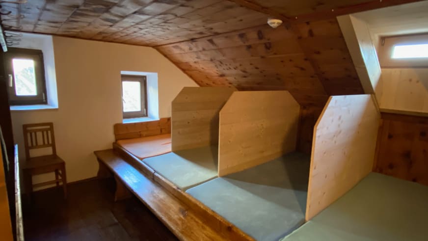 Schlaflager der Richterhütte im Dachgeschoss mit drei Holzkojen und sichtbaren Dachbalken.