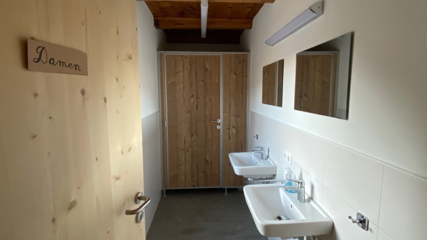 Funktionaler Waschraum der Richterhütte mit zwei Waschbecken und Holzvertäfelung.