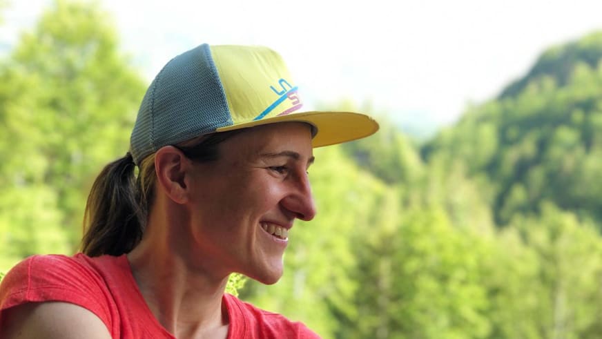 Profilaufnahme der lächelnden Bergwanderführerin Elisabeth Götzinger mit gelb-blauer Basecap.