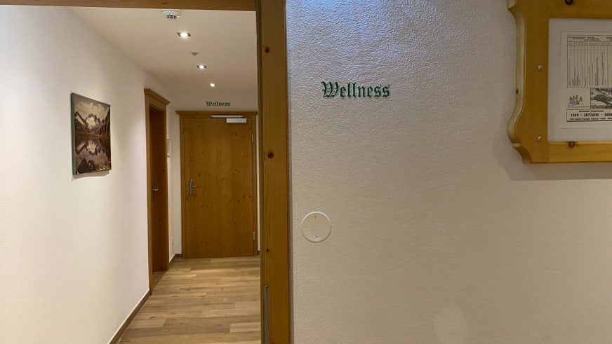 Moderner Flur mit Holzelementen führt zum Wellnessbereich im Krimmler Tauernhaus.