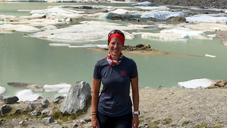 Portrait von Bergwanderführerin Alexandra Querl vor türkisfarbenem Gletschersee mit schwimmenden weißen Eisschollen.