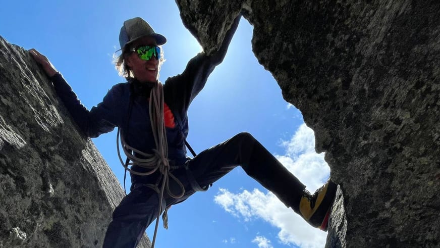 In einer engen Felsspalte stemmt sich Bergführer Tobias Riedlsperger mit gelben Kletterschuhen gegen die Felswände.