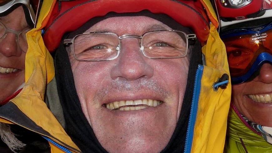 Mit rotem Helm und gelber Jacke lächelt Bergwanderführer Reinald Zölch in die Kamera.