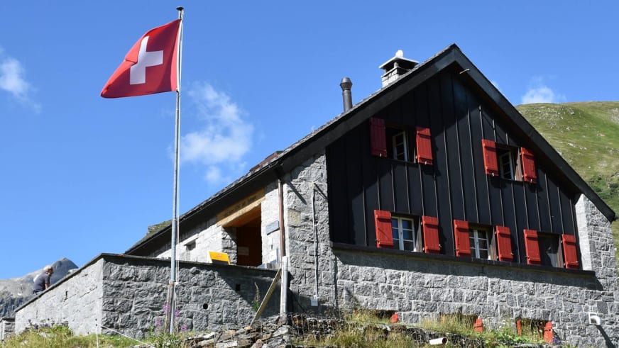 Die Vermigelhütte steht als zweistöckiges Gebäude mit Naturstein und Holzverkleidung in alpiner Landschaft.