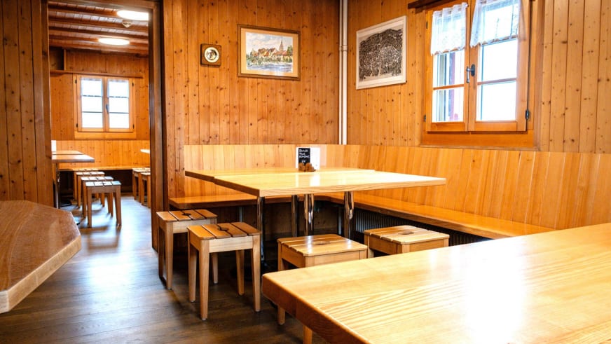 Gaststube der Vermigelhütte mit heller Holzvertäfelung, Holztischen und Bänken im traditionellen Stil.