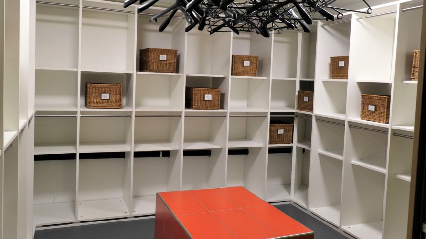 Garderobe der Vermigelhütte mit weißen Holzregalen, Korbboxen und Trockenvorrichtungen für Bergausrüstung.