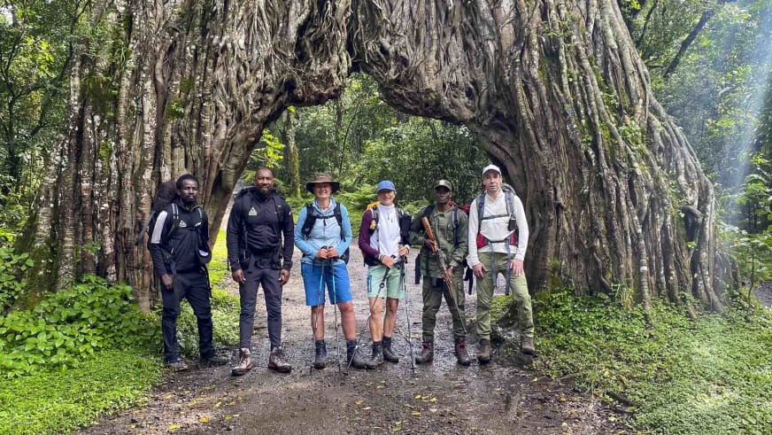 Wandergruppe mit Bergführer vor großem Feigenbaum-Tor auf dem Weg zur Miriakamba Hütte am Mount Meru.