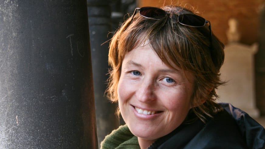 Portrait von Bergwanderführerin Birgit Eder im Innenraum mit braunen Haaren und dunkelblauer Jacke.