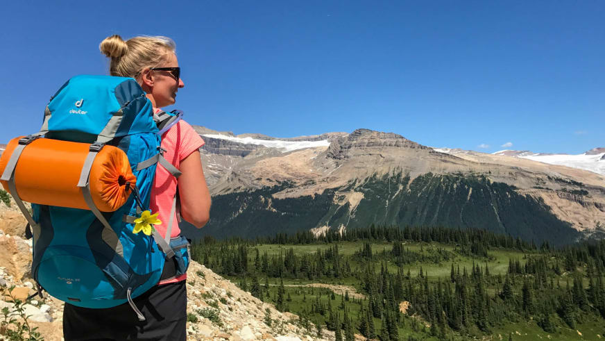 Bergwanderführerin Stefanie Erdmann trägt großen türkisen Trekkingrucksack auf steinigem Berghang.