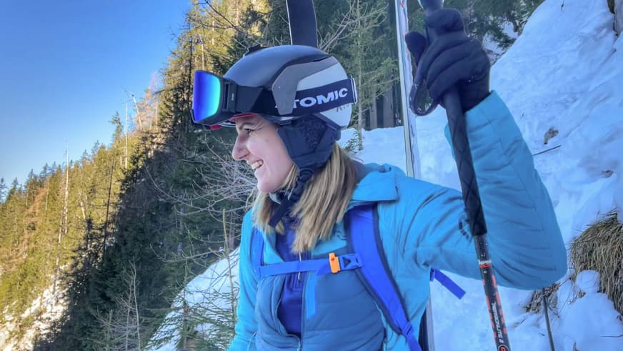 Mit Skibrille und Skistöcken steht Bergwanderführerin Alina Elisabeth Leitinger in blauer Skijacke im Schnee.