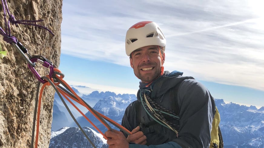 Bergführer Lukas Seedoch hält orangefarbene Kletterseile in den Händen vor schneebedecktem Bergpanorama.